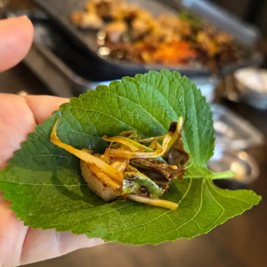 깻잎 위에 고기와 김치를 올린 한입 쌈